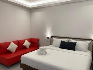 a bedroom with two beds and a red couch at CS Junction Point - Double Deluxe Room - DDR in Kuala Pilah