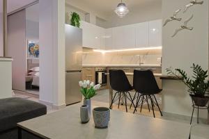 a kitchen and living room with a table and chairs at Zeta - Garden Oasis with Private Parking in Katerini