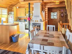 eine Küche und ein Esszimmer mit einem Tisch und einem Kamin in der Unterkunft Holiday Home Alppi 7b paritalo by Interhome in Hyrynsalmi