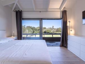 - une chambre avec un grand lit et une grande fenêtre dans l'établissement Apartment Le studio du Domaine le Petit Sperone by Interhome, à Bonifacio
