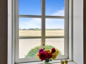 a vase of flowers sitting in a window at Holiday Home Ulv - 20km from the sea in Western Jutland by Interhome in Ribe