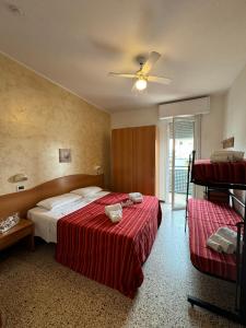 Camera con 2 letti e un ventilatore a soffitto. di Hotel Caruso a Rimini
