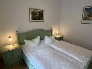 een slaapkamer met een wit bed en 2 nachtkastjes bij Apartment Ostseetrio App-7 by Interhome in Zinnowitz