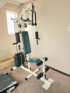 a room with a gym with a treadmill and a chair at Downham Views in Johannesburg
