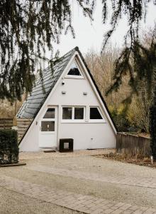 a white garage with a pitched roof at Naturhaus am Felsenweg in Mitlosheim