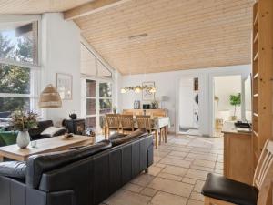 ein Wohnzimmer mit einem Sofa und einem Tisch in der Unterkunft Holiday Home Ehlin - 150m from the sea in NE Jutland by Interhome in Sæby