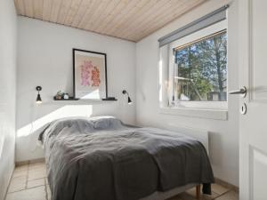 Schlafzimmer mit einem Bett und einem Fenster in der Unterkunft Holiday Home Ehlin - 150m from the sea in NE Jutland by Interhome in Sæby