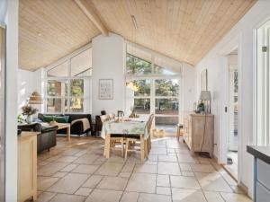 eine Küche und ein Wohnzimmer mit einem Tisch und Stühlen in der Unterkunft Holiday Home Ehlin - 150m from the sea in NE Jutland by Interhome in Sæby