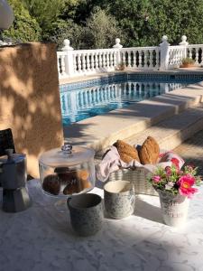 a table with cookies and a tea pot and flowers at Casa con piscina in Calpe