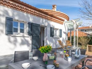 a patio with a table and chairs and a house at Holiday Home Saint Hubert by Interhome in Mimizan