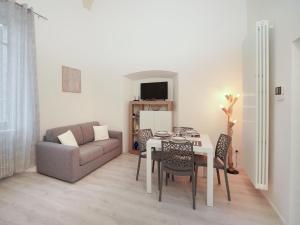 een woonkamer met een tafel en een bank bij Apartment Le Volte by Interhome in Porto Valtravaglia