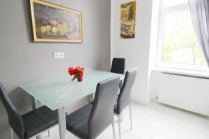 a dining room table with chairs and a vase of flowers at W Apartment - Brigittenau Area MM15 in Vienna