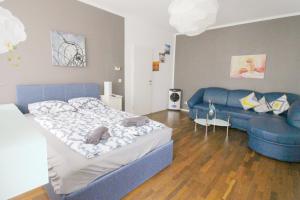 a bedroom with a blue bed and a couch at W Apartment - Brigittenau Area MM15 in Vienna