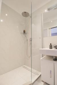a white bathroom with a shower and a sink at W Apartment - Brigittenau Area MM15 in Vienna