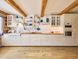 uma cozinha com armários brancos e tectos em madeira em Holiday Home Hanička by Interhome em Horní Marsov