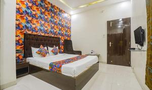 Schlafzimmer mit einem Bett mit Wandgemälde in der Unterkunft The JK Hotel - Opp Railway Station, Civil Lines, Sadar, Nagpur in Nagpur