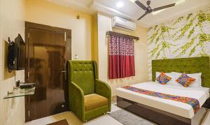 um quarto com uma cama verde e uma cadeira em The JK Hotel - Opp Railway Station, Civil Lines, Sadar, Nagpur em Nagpur