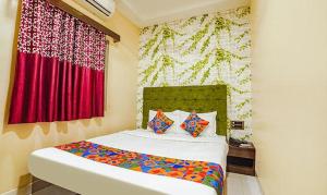 Schlafzimmer mit einem Bett mit roten Vorhängen in der Unterkunft The JK Hotel - Opp Railway Station, Civil Lines, Sadar, Nagpur in Nagpur
