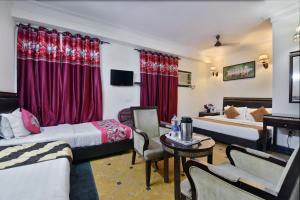 a hotel room with two beds and a table at Hotel By Yellow Revels Plum in New Delhi