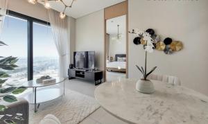 Address Beach Resort Apartment في دبي: غرفة معيشة مع طاولة وتلفزيون