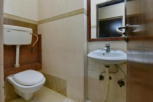 Hotel By Yellow Revels Plum في نيودلهي: حمام مع مرحاض ومغسلة ومرآة
