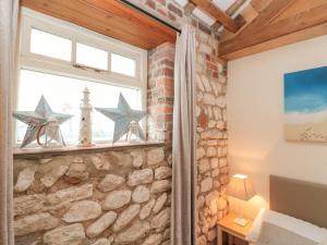 a room with a window with stars on a stone wall at Fulmar Cottage in Bridlington