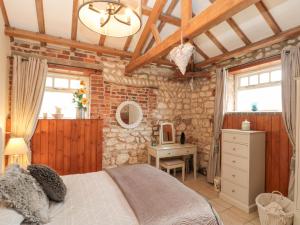 a bedroom with a bed and a stone wall at Fulmar Cottage in Bridlington