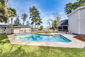 a swimming pool in a yard next to a house at Riverfront Savannah Getaway with Pool and Dock! in Savannah