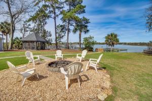 a fire pit with chairs and a gazebo at Riverfront Savannah Getaway with Pool and Dock! in Savannah