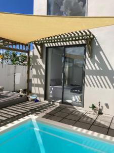 eine Terrasse mit einer Glastür neben einem Pool in der Unterkunft Villa Trou d'Eau Douce in Trou dʼ Eau Douce