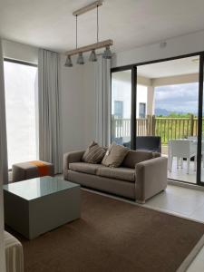 ein Wohnzimmer mit einer Couch und einem Tisch in der Unterkunft Villa Trou d'Eau Douce in Trou dʼ Eau Douce
