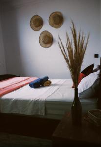 1 dormitorio con 1 cama con sombreros en la pared en Onda Surf en Taghazout