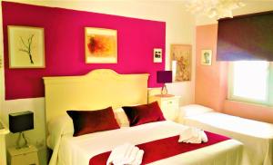 a bedroom with two beds and a red wall at B&B Domus de Janas Santa Teresa Gallura in Santa Teresa Gallura