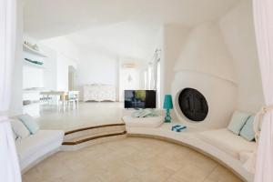 a living room with a clock on the wall at Villa Stella Turchese - IUN F0243 in Torre delle Stelle