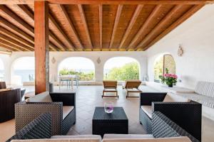 ein Wohnzimmer mit Möbeln und einer Holzdecke in der Unterkunft Villa Stella Turchese - IUN F0243 in Torre delle Stelle