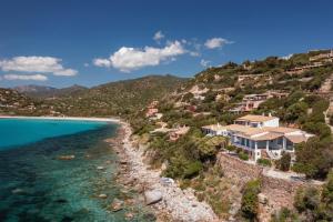 Blick auf einen Strand mit Häusern auf einem Hügel in der Unterkunft Villa Stella Turchese - IUN F0243 in Torre delle Stelle