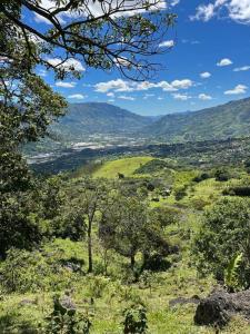 a view of a valley from a hill with trees at Casa Nutabe - Casa de Campo en Girardota cerca a Medellín in Girardota