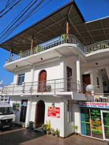 un edificio blanco con balcón en la parte superior en Oyado Marufuku en Kandy