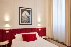 ein Schlafzimmer mit einem roten Kopfteil und einem Bett mit roten Kissen in der Unterkunft Firenze Rooms Cathedral B&B in Florenz