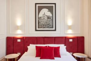 a bedroom with a red headboard and red pillows at Firenze Rooms Cathedral B&B in Florence