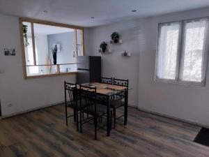a kitchen with a table and chairs in a room at ''L' éphémère escale'' appartement calme avec parking gratuit sur place in Montbrison