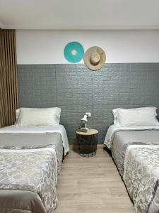 1 dormitorio con 2 camas y un sombrero en la pared en Apartamento Kalea corazón urbano, en Vitoria-Gasteiz