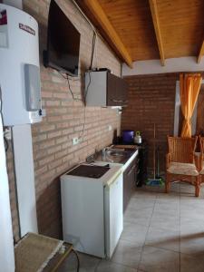 cocina con fregadero y fogones horno superior en Cabañas La Peperina 2 in 