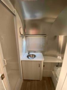 a small bathroom with a sink in a tiny house at Modern Airstream with amazing view - 10 to 15 minutes from Kings Canyon National Park in Dunlap
