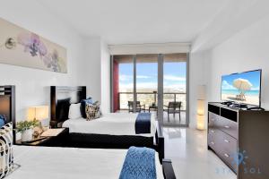 een slaapkamer met een bed en uitzicht op de oceaan bij Breathtaking 31st Fl Beachwalk Penthouse View in Hallandale Beach
