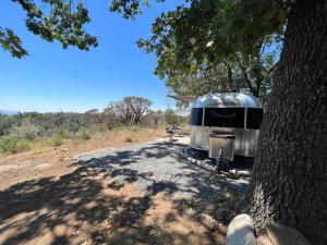 un remolque plateado estacionado junto a un árbol en Modern Airstream with amazing view - 10 to 15 minutes from Kings Canyon National Park en Dunlap