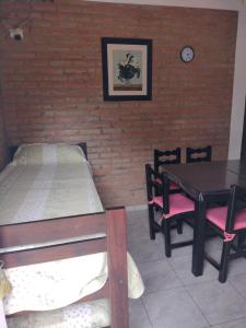 1 dormitorio con 1 cama, mesa y sillas en Cabañas La Peperina 2 in 