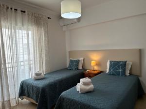 dwa łóżka z pluszakami siedzącymi na nich w pokoju w obiekcie Apartamento Canaima w mieście Quarteira