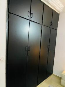 a row of black lockers in a room at 2 pièces très moderne à Cocody Angré Château in Cocody