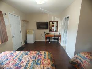 a bedroom with a bed and a table and a television at Relax Inn-Collingwood in Collingwood